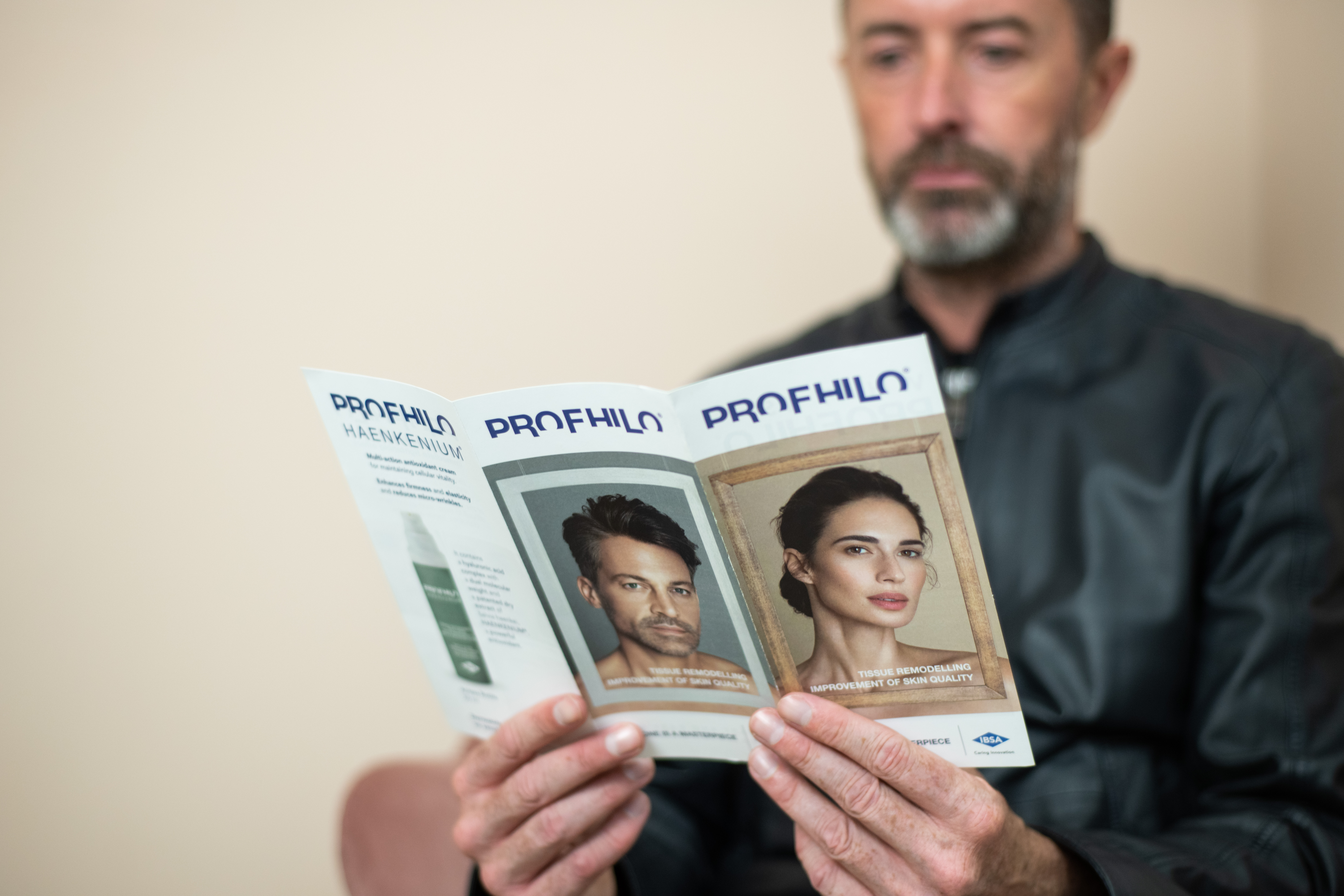 Handsome man reading profhilo booklet learning about the treatment